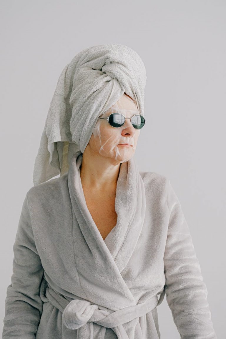 A relaxed woman in bathrobe, towel and face maskA relaxed woman in bathrobe, towel and face mask