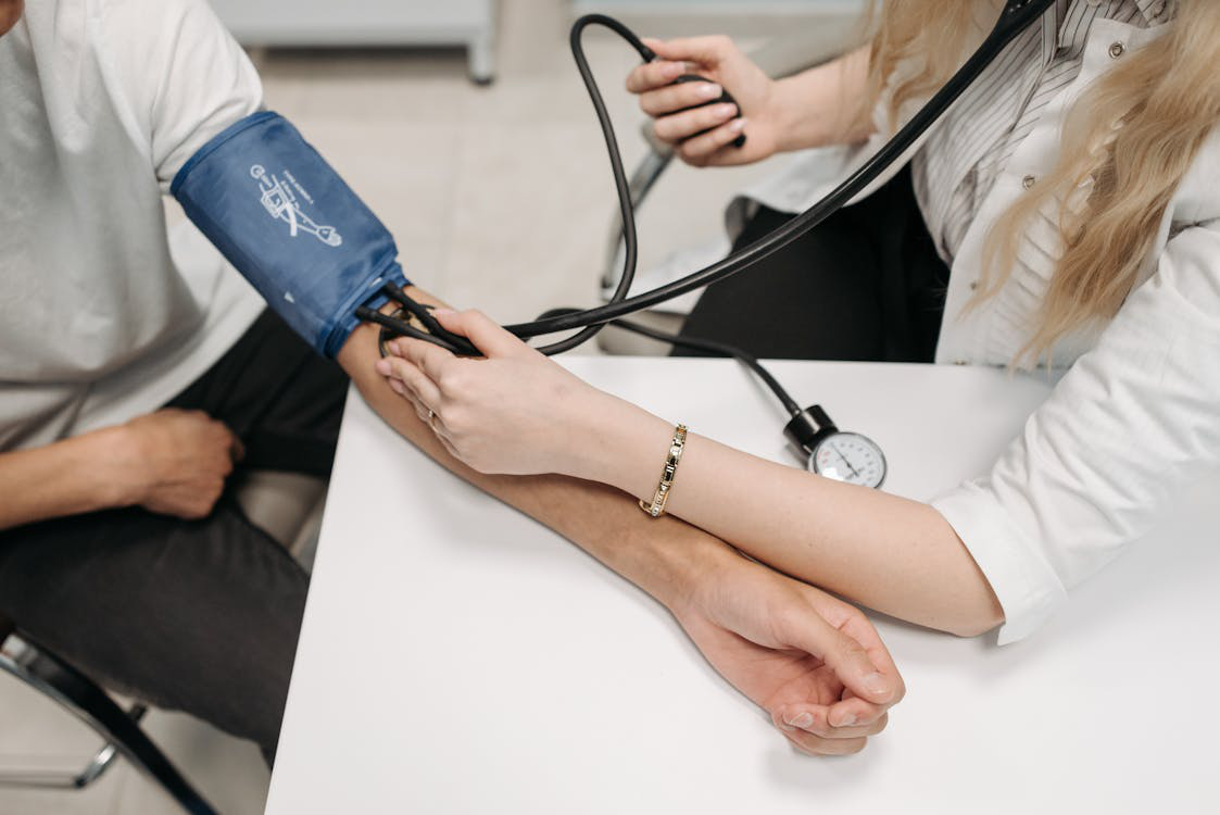 A doctor monitoring a patient’s blood pressure