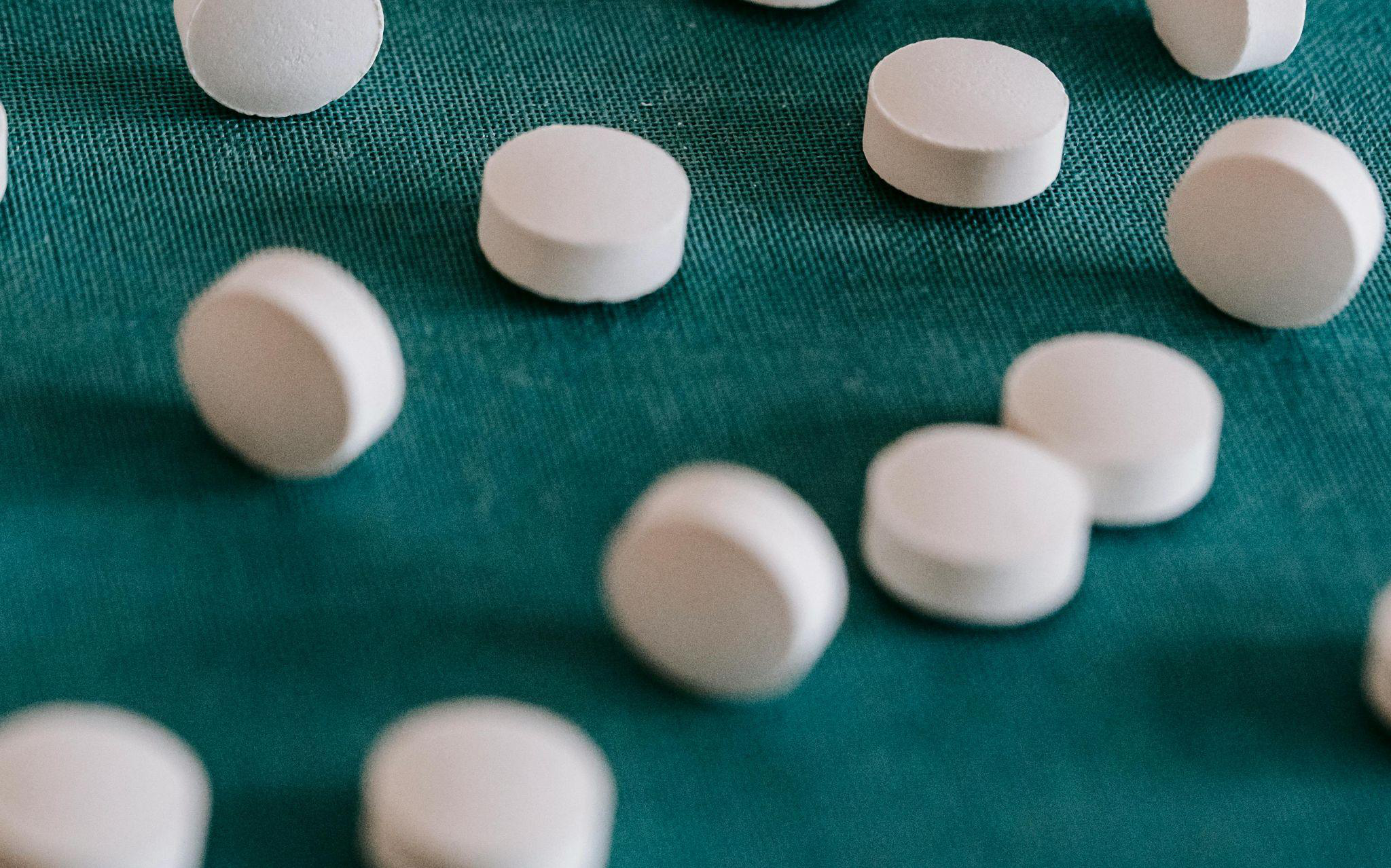 White pills scattered across a blue textured background