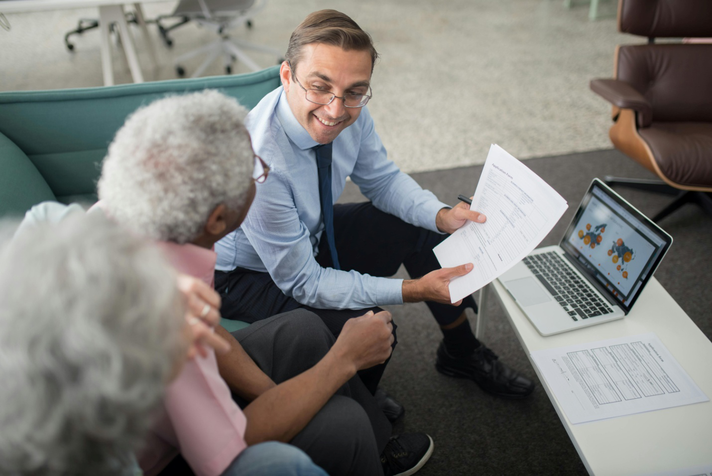 A healthcare professional assisting a patient with a prescription assistance application form.