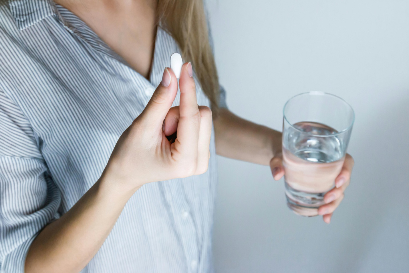 A person about to take a pill with water