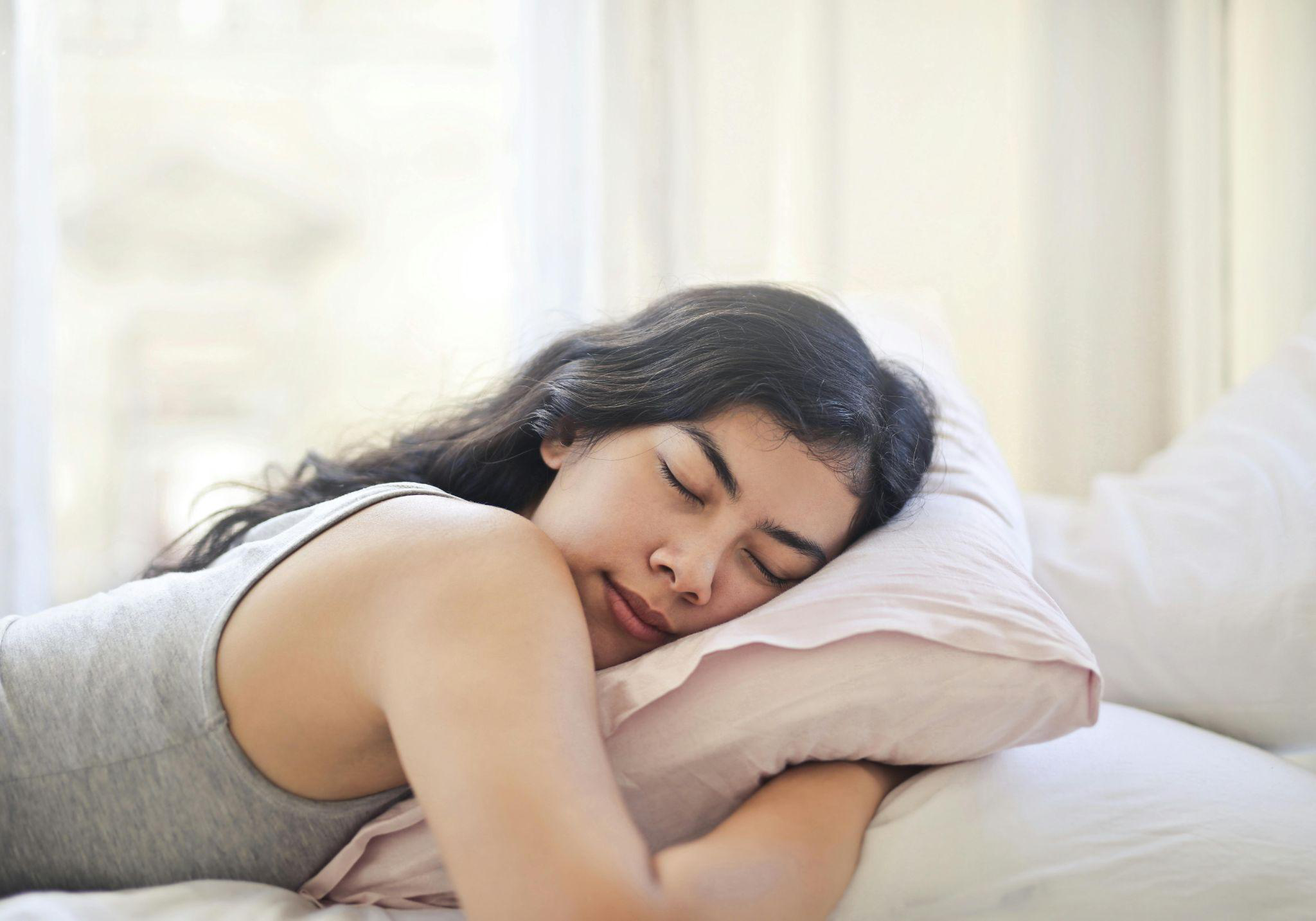 Close up of a girl comfortably sleeping on her bed