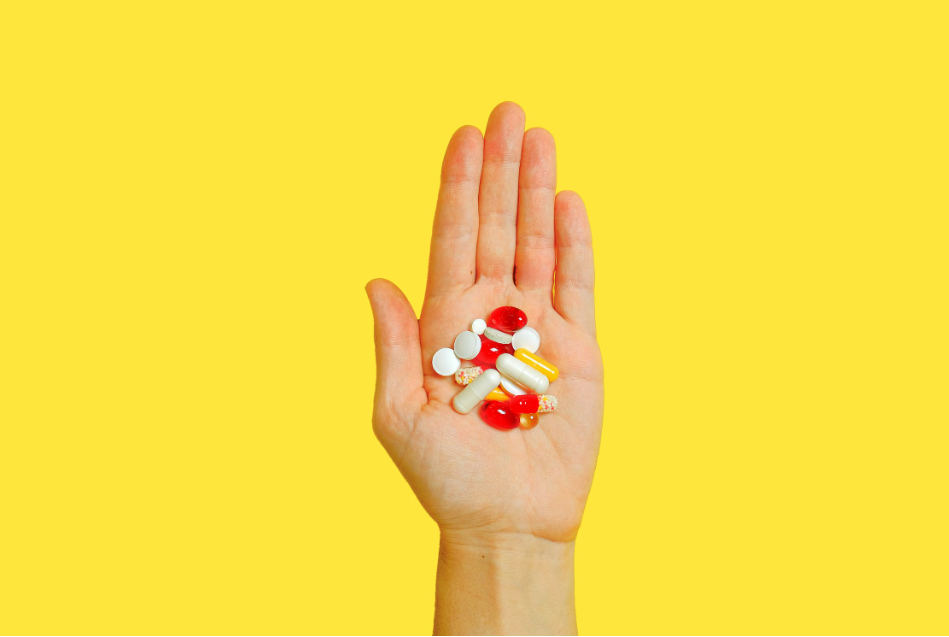 A person holding a wide assortment of medication