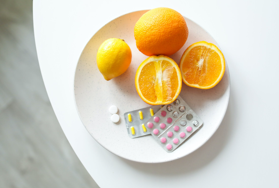 An orange and blister packs of medicines on a plate