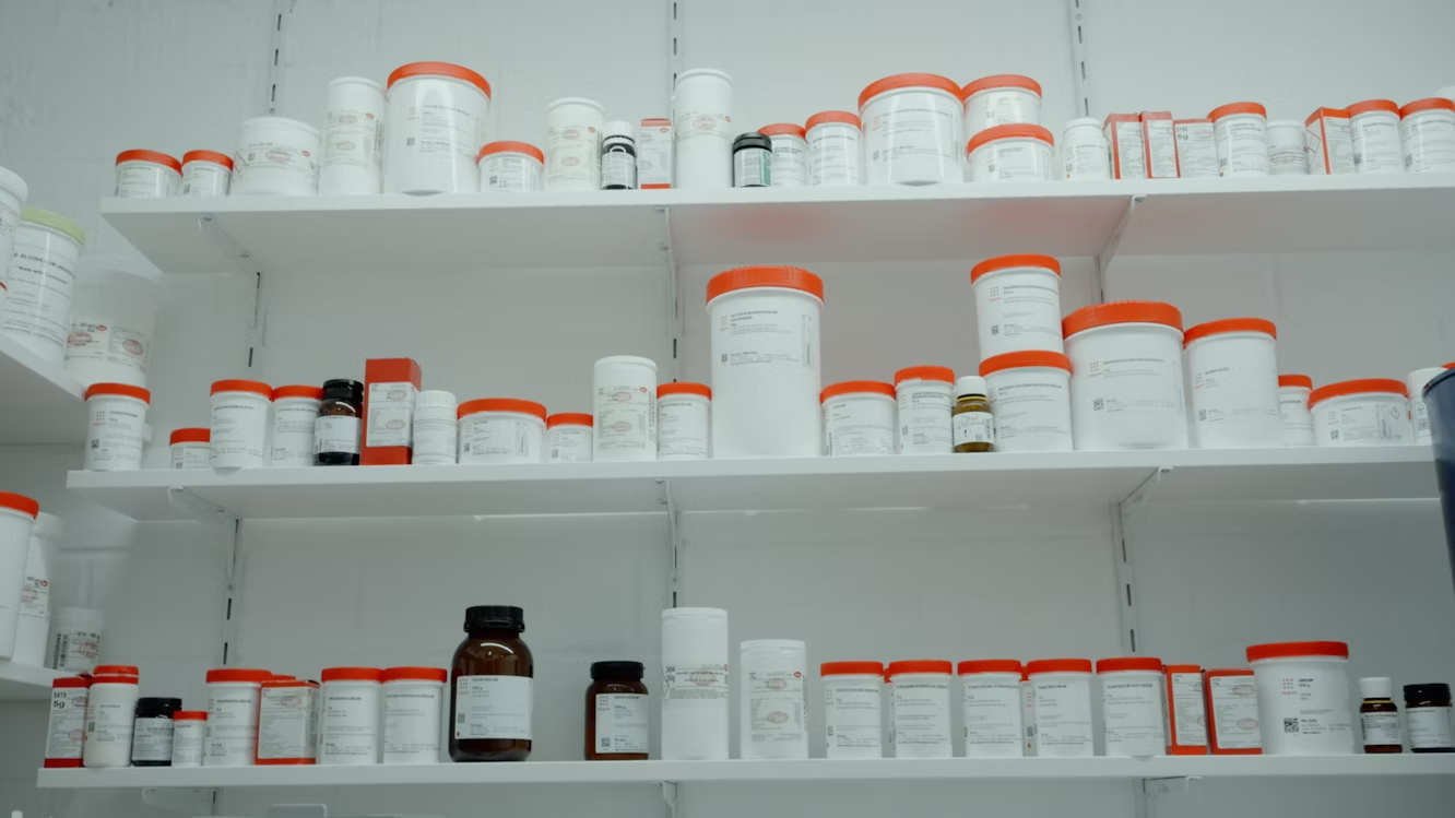 Pharmacy shelves stocked with orange and white medication bottles