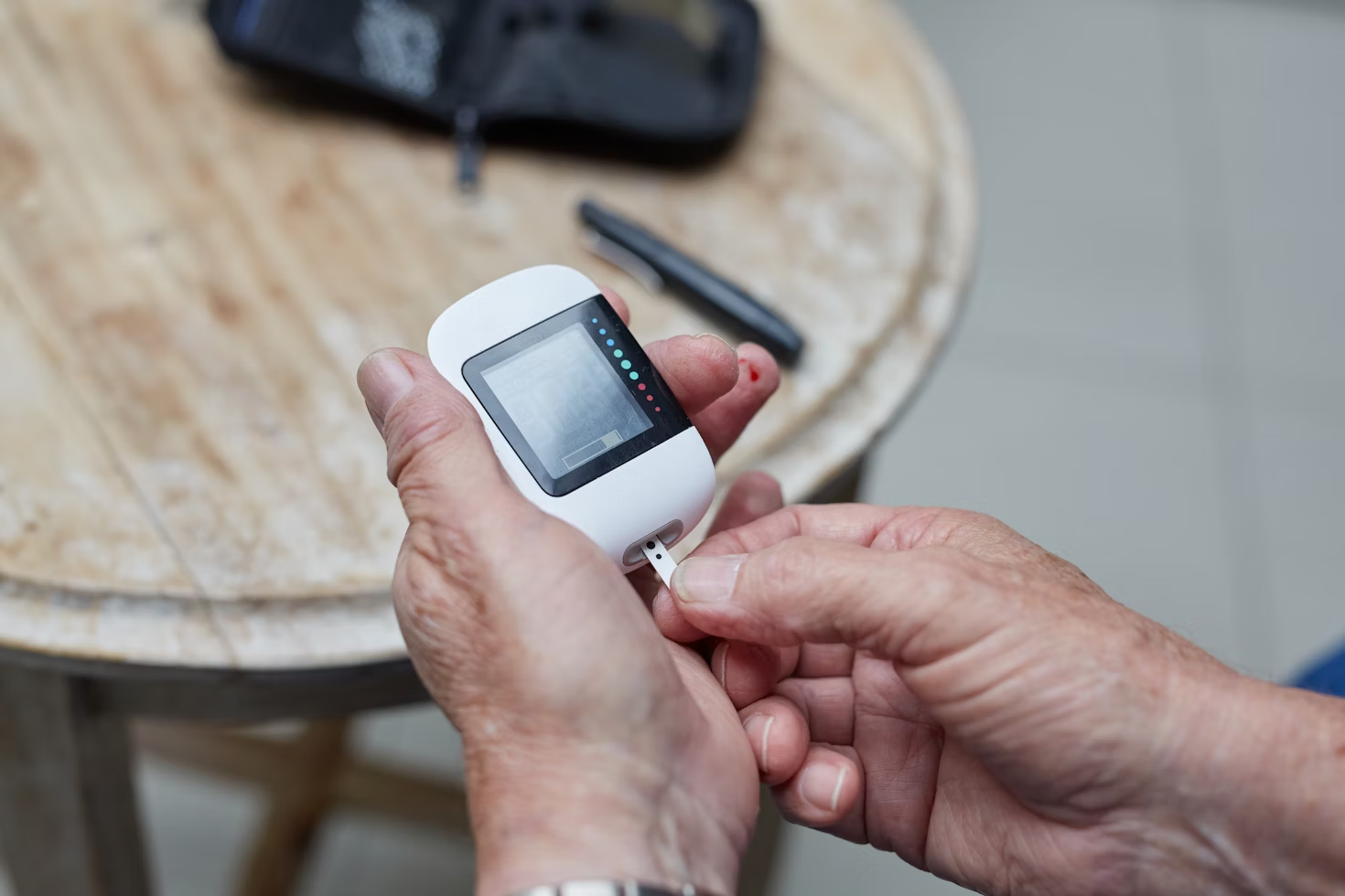 Person using a glucose meter to check blood sugar levels at home