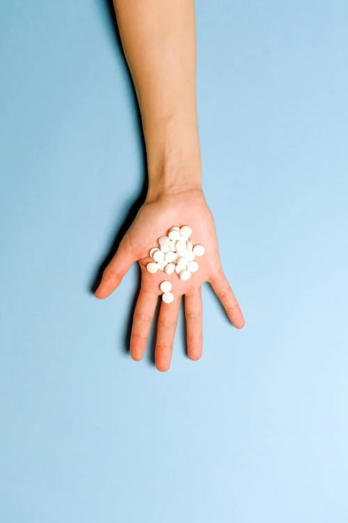 Person holding round medicine pills