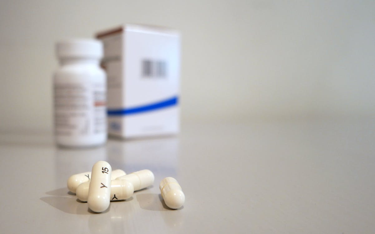 Five oblong medication pills arranged on a surface, symbolizing various prescriptions and treatment needs.