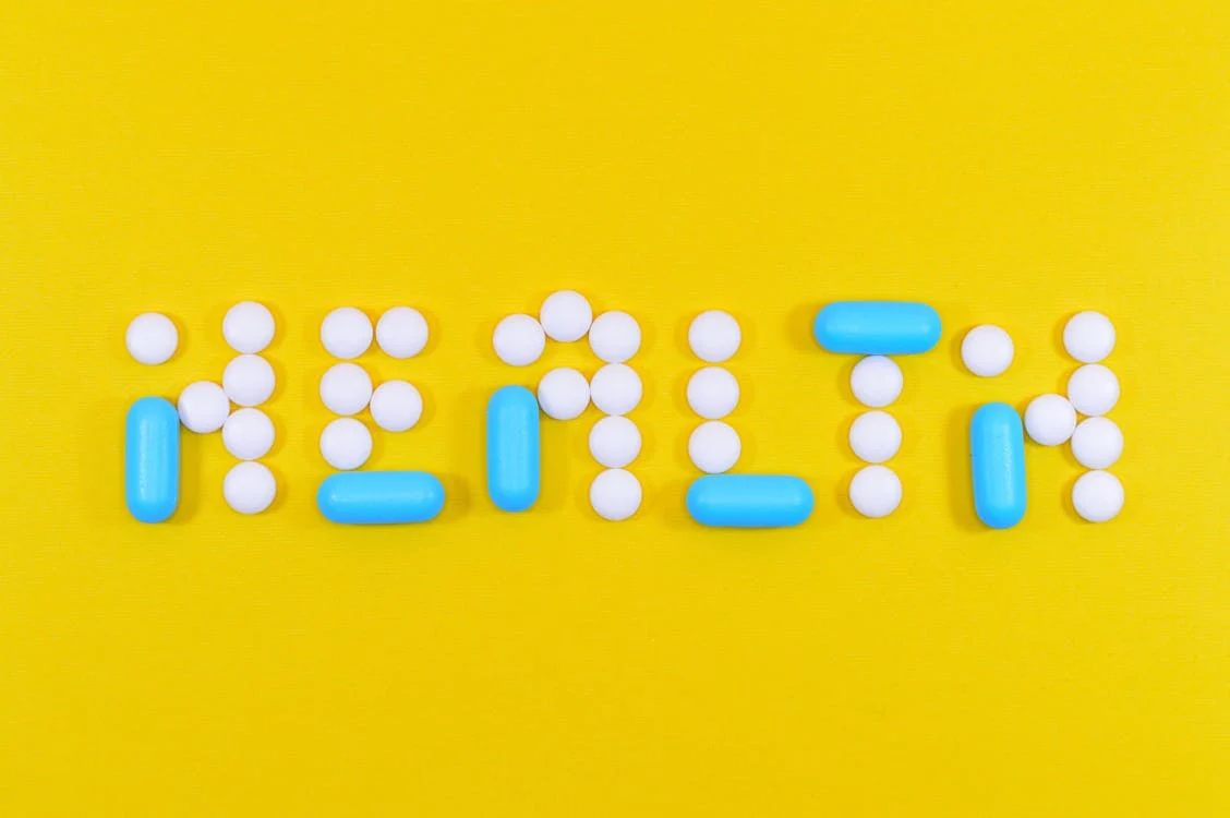The word “health” spelled using pills on a yellow background