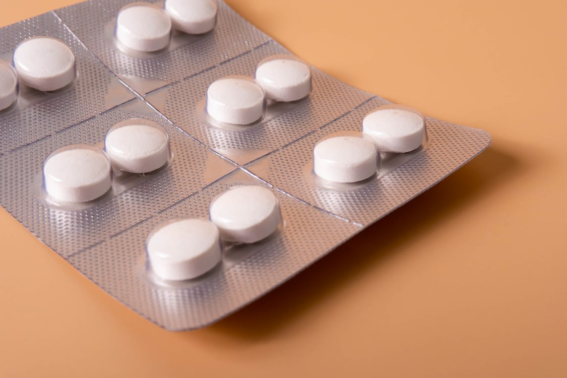 White tablets sealed in blister packaging on a neutral background