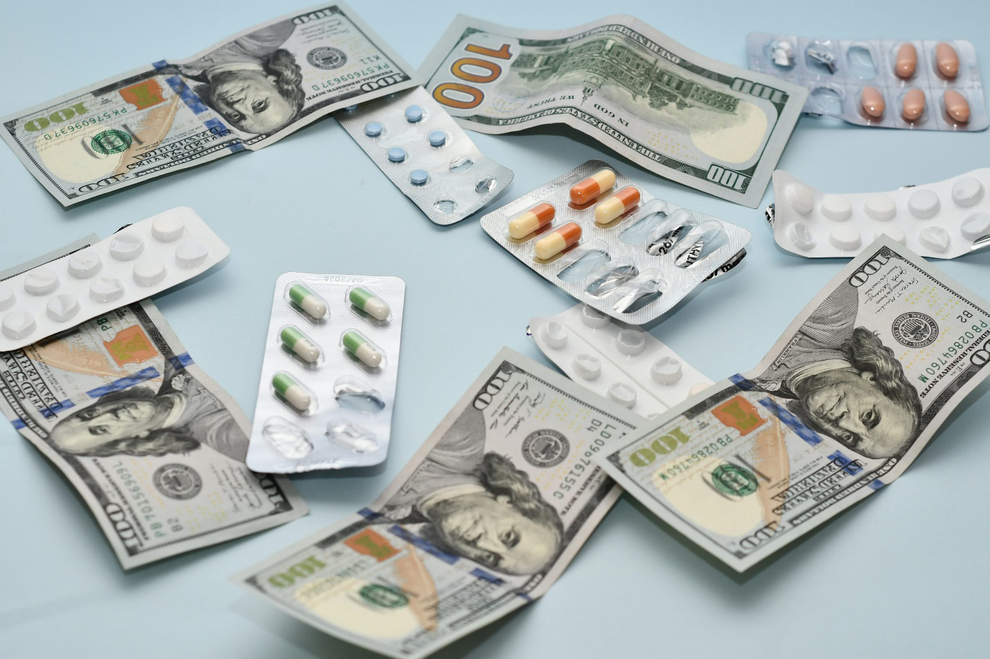 Medication bottles next to calculator and bills showing financial strain of prescriptions