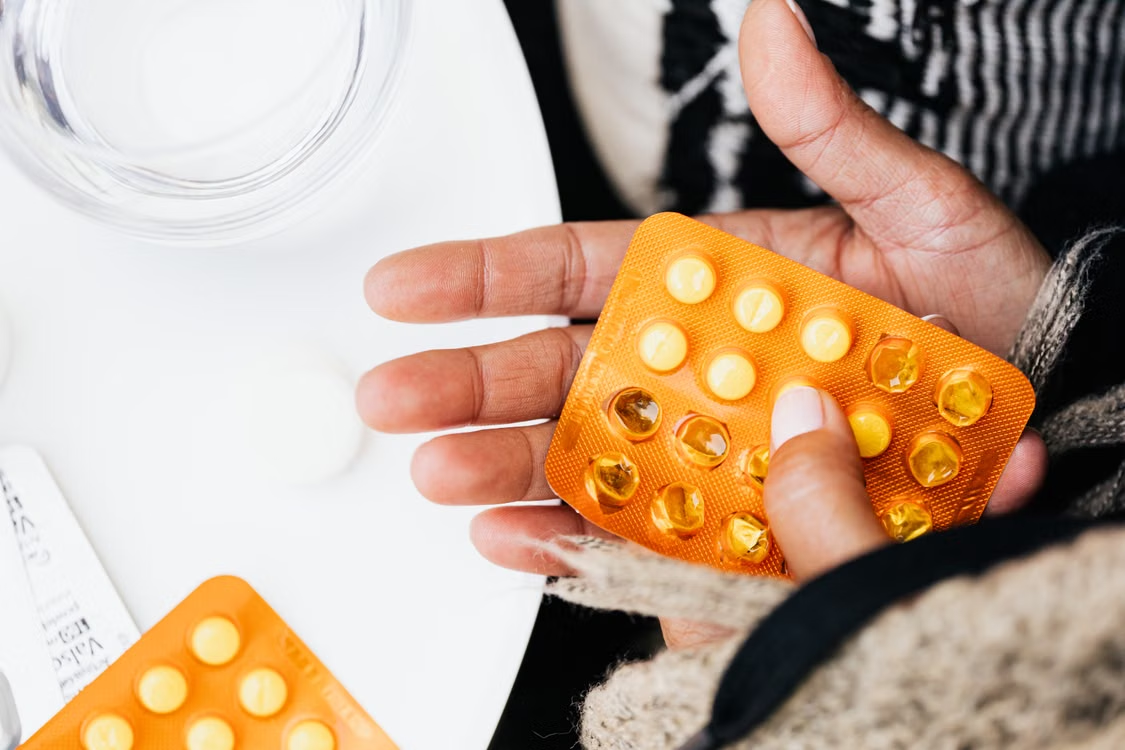 Patient holding a blister pack of prescription medication before taking the prescribed dose