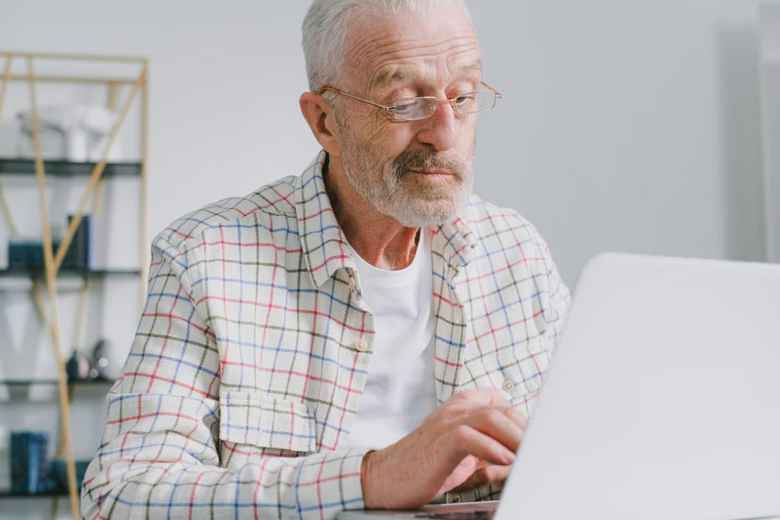 Older adult using a laptop to access an online prescription management portal