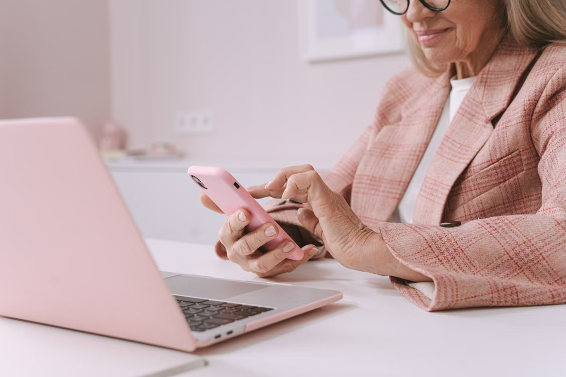 Older adult using a smartphone and laptop to manage prescription medications online