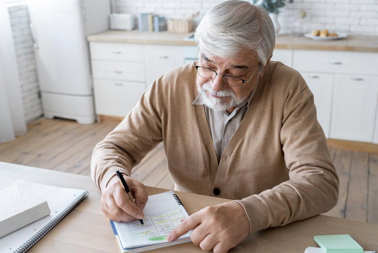 Older man reviewing financial information and planning for ongoing prescription expenses.