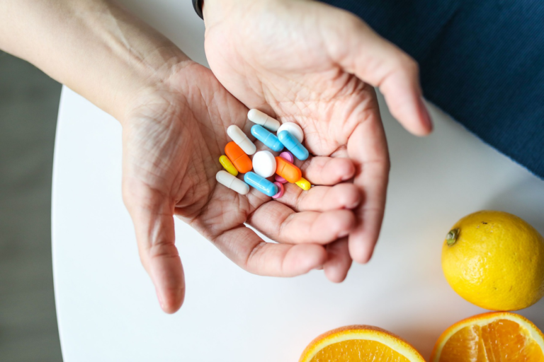 Person holding multiple medications while evaluating prescription assistance options