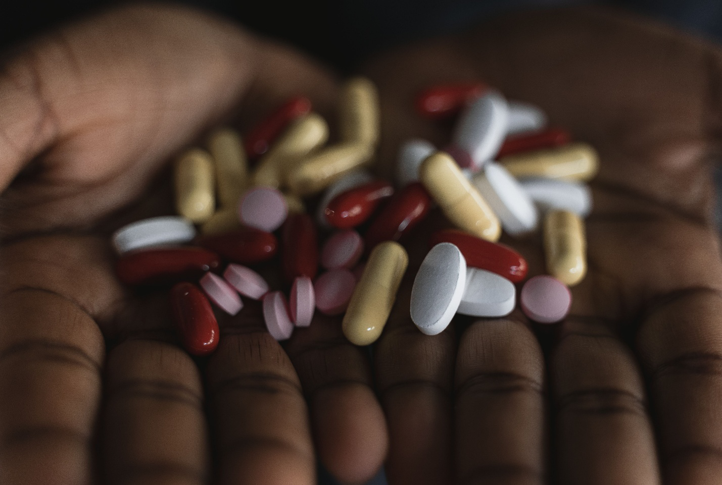 Person holding different prescription medications used to represent barriers to mental health treatment